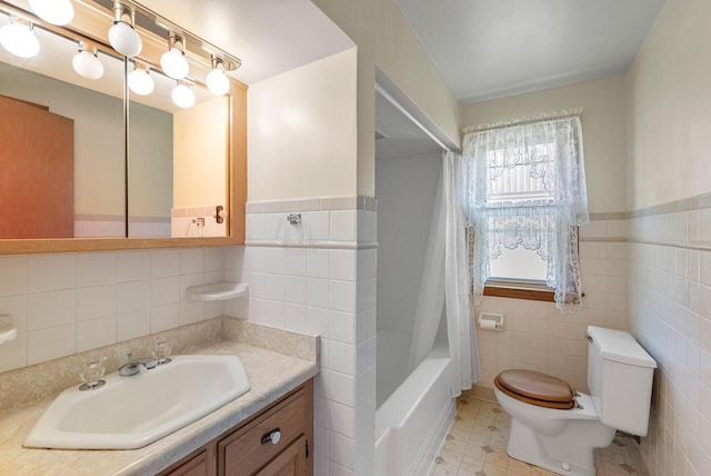 2109 Salisbury Rd, West Bend, WI 53090 - bathroom featuring tile walls, toilet, vanity, shower / bath combo, and a wainscoted wall