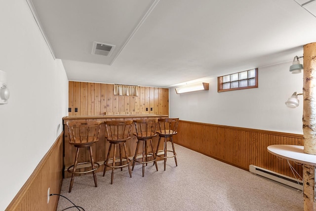 2109 Salisbury Rd, West Bend, WI 53090 - indoor bar featuring a baseboard radiator, wood walls, light colored carpet, and wainscoting