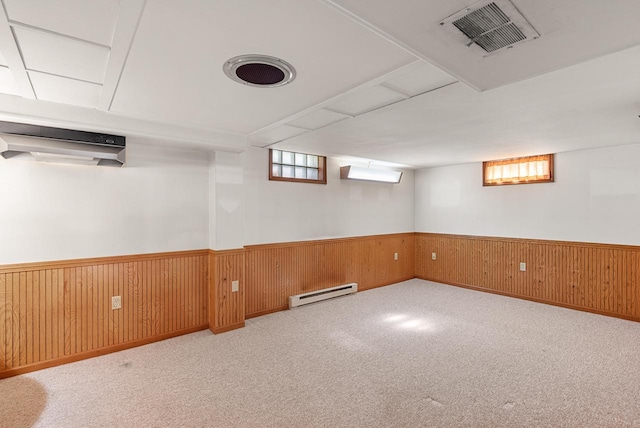 2109 Salisbury Rd, West Bend, WI 53090 - below grade area featuring a baseboard heating unit, a wainscoted wall, carpet flooring, wood walls, and an AC wall unit