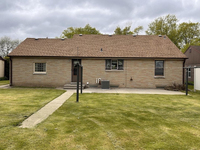 2109 Salisbury Rd, West Bend, WI 53090 - rear view of property with roof with shingles, a patio, a lawn, brick siding, and entry steps