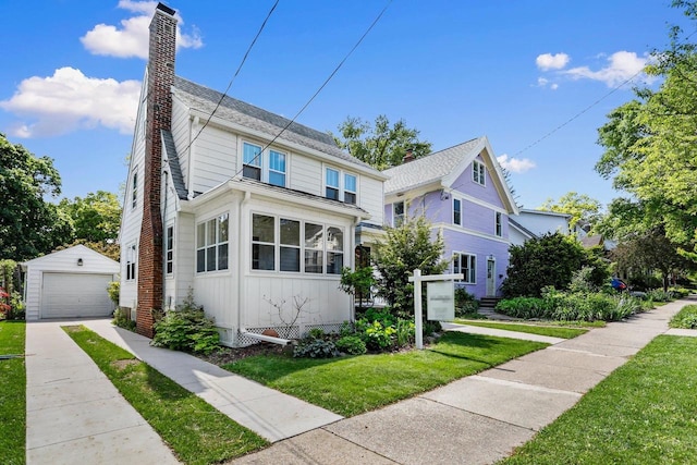 644 Crandall St, Madison, WI 53711 - view of front of property with a detached garage, an outdoor structure, a chimney, driveway, and a front yard