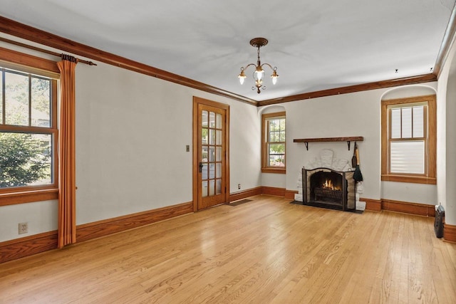 644 Crandall St, Madison, WI 53711 - unfurnished living room featuring light wood-type flooring, baseboards, a fireplace with flush hearth, ornamental molding, and a chandelier