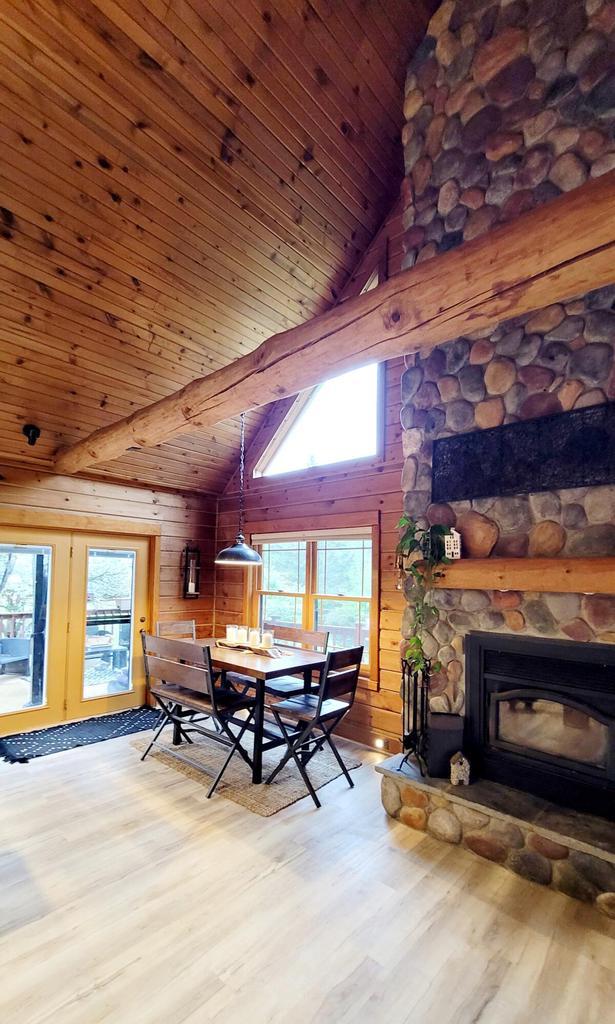 610 Fox Ridge Ct, Nekoosa, WI 54457 - dining room featuring wood finished floors, high vaulted ceiling, wooden ceiling, a fireplace, and wood walls