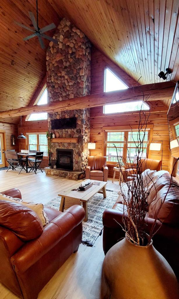 610 Fox Ridge Ct, Nekoosa, WI 54457 - living room with wood ceiling, wood finished floors, high vaulted ceiling, wood walls, and a fireplace