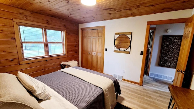610 Fox Ridge Ct, Nekoosa, WI 54457 - bedroom featuring light wood-style floors, wood walls, wooden ceiling, and a closet