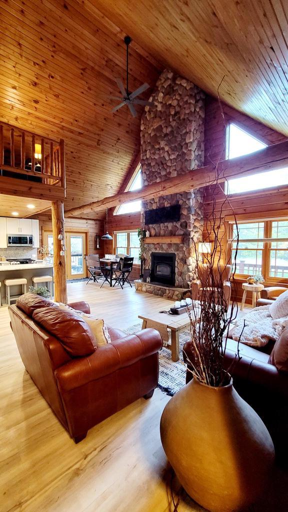 610 Fox Ridge Ct, Nekoosa, WI 54457 - living area with high vaulted ceiling, wood ceiling, wood finished floors, ceiling fan, and a stone fireplace