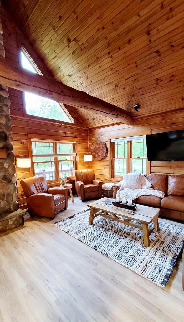610 Fox Ridge Ct, Nekoosa, WI 54457 - living area with plenty of natural light, wooden walls, wood finished floors, a wood ceiling with exposed beams, and a skylight