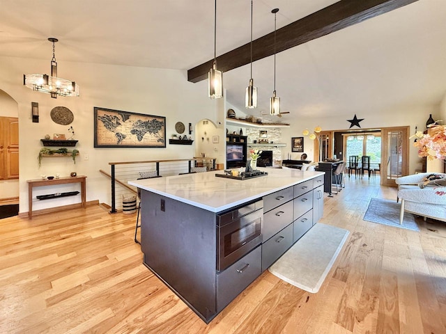 2728 E Ridge Rd, Beloit, WI 53511 - kitchen with built in microwave, open floor plan, arched walkways, light wood-style flooring, and light countertops