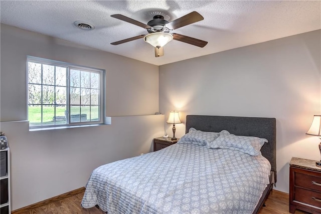 N4907 572nd St, Menomonie, WI 54751 - bedroom with wood finished floors, a textured ceiling, a ceiling fan, and baseboards