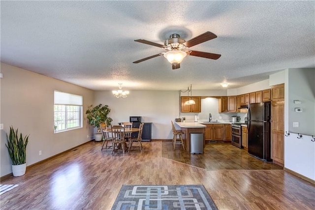 N4907 572nd St, Menomonie, WI 54751 - kitchen with freestanding refrigerator, a sink, light countertops, a textured ceiling, and wood finished floors