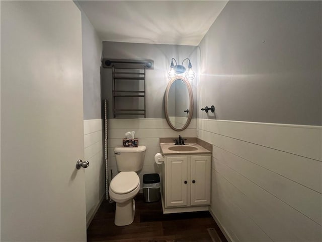 N2673 464th St, Menomonie, WI 54751 - half bathroom featuring vanity, wood finished floors, toilet, a wainscoted wall, and tile walls