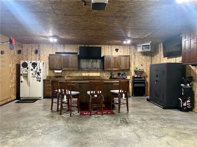 N2673 464th St, Menomonie, WI 54751 - kitchen featuring white fridge with ice dispenser, concrete flooring, a kitchen island, and dark countertops