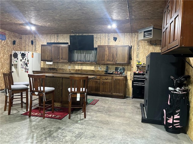 N2673 464th St, Menomonie, WI 54751 - kitchen featuring concrete flooring, white fridge with ice dispenser, dark countertops, a kitchen island, and dark brown cabinetry