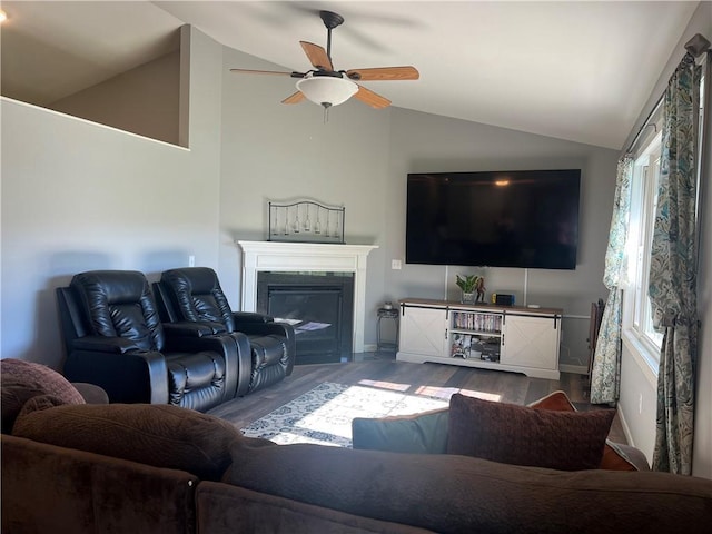 N2673 464th St, Menomonie, WI 54751 - living room featuring vaulted ceiling, wood finished floors, a ceiling fan, a glass covered fireplace, and plenty of natural light