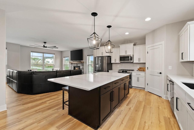 788 Kohlwey Dr, Grafton, WI 53024 - kitchen featuring stainless steel appliances, backsplash, light countertops, white cabinetry, and recessed lighting