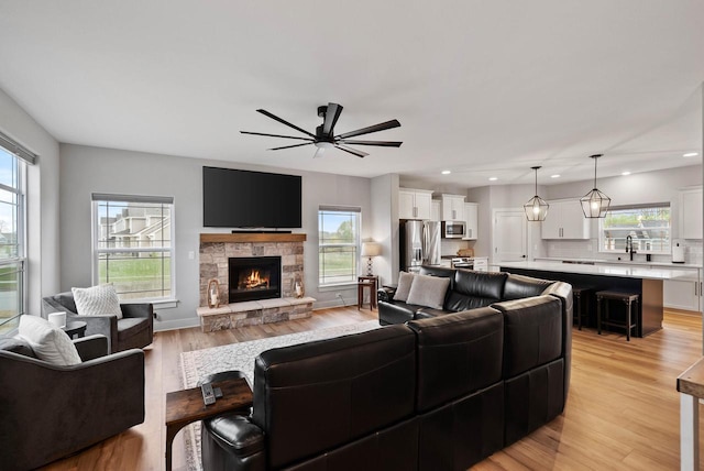 788 Kohlwey Dr, Grafton, WI 53024 - living room with healthy amount of natural light, ceiling fan, light wood-type flooring, recessed lighting, and a fireplace