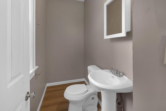 3421 W Clybourn Ave Unit 3423, Milwaukee, WI 53208 - bathroom featuring toilet, baseboards, and wood finished floors