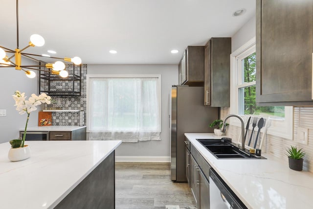 71 Menomonee St, Williams Bay, WI 53191 - kitchen with a sink, light wood finished floors, decorative backsplash, a chandelier, and dark brown cabinets