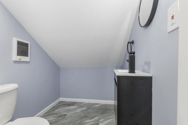 71 Menomonee St, Williams Bay, WI 53191 - half bathroom featuring toilet, vaulted ceiling, marble look tiles, baseboards, and vanity
