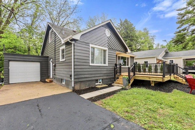 71 Menomonee St, Williams Bay, WI 53191 - view of front facade with asphalt driveway, a deck, and a garage