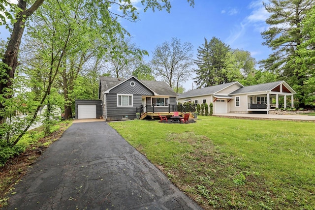 71 Menomonee St, Williams Bay, WI 53191 - view of front of house with a front lawn, asphalt driveway, a garage, and an outbuilding
