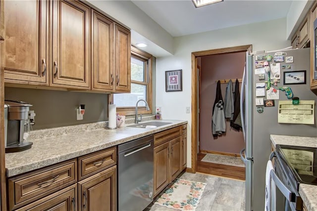 616 E Polk Ave, Eau Claire, WI 54701 - kitchen with dishwasher, a sink, light countertops, brown cabinetry, and baseboards