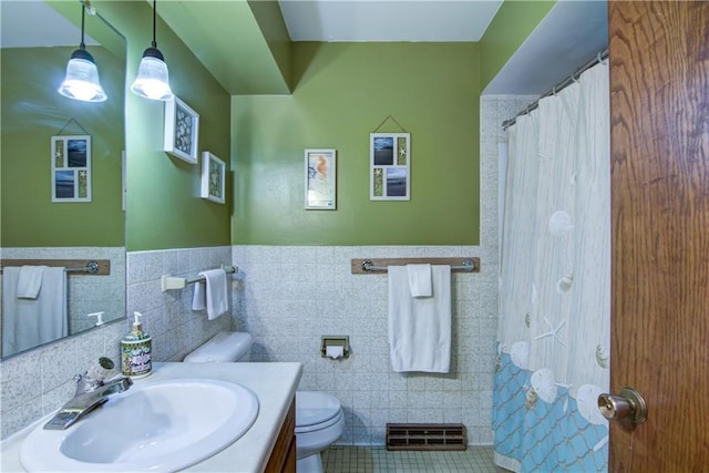 616 E Polk Ave, Eau Claire, WI 54701 - full bathroom featuring toilet, vanity, tile walls, tile patterned floors, and wainscoting