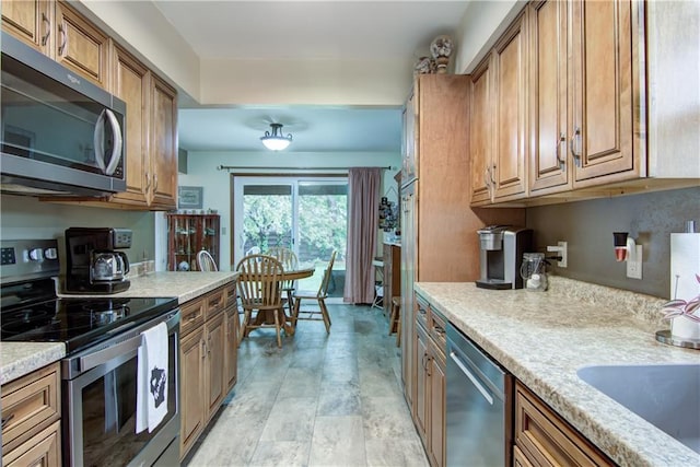 616 E Polk Ave, Eau Claire, WI 54701 - kitchen featuring stainless steel appliances, brown cabinets, and stone finish floors