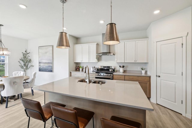 6655 Royal View Dr, Windsor, WI 53532 - kitchen featuring wall chimney range hood, stainless steel gas range oven, a sink, light wood-type flooring, and recessed lighting