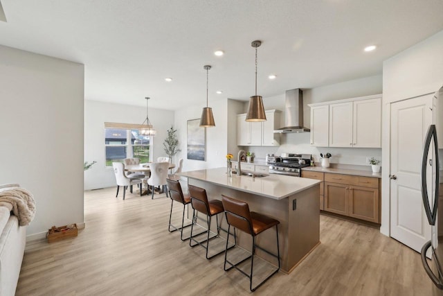 6655 Royal View Dr, Windsor, WI 53532 - kitchen with wall chimney exhaust hood, stainless steel gas range oven, a sink, light wood-style flooring, and a breakfast bar