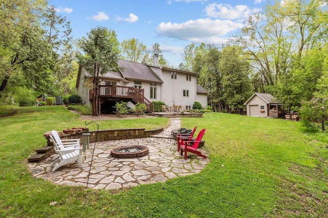 3196 Hidden Pond Rd, Green Bay, WI 54313 - view of green lawn featuring an outdoor fire pit, a wooden deck, a patio, stairway, and an outdoor structure