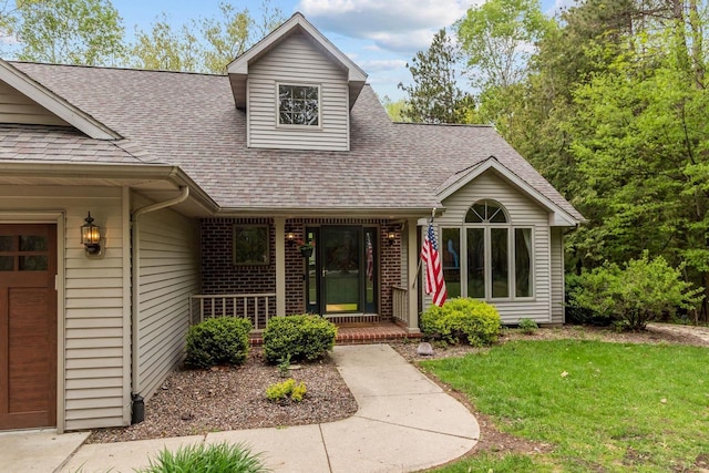 3196 Hidden Pond Rd, Green Bay, WI 54313 - view of front of property with roof with shingles, a porch, a front lawn, and brick siding