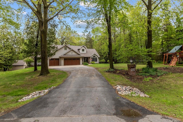 3196 Hidden Pond Rd, Green Bay, WI 54313 - view of front facade with a garage, a front lawn, driveway, and a playground