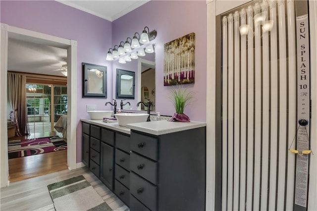 630 W Lake Dr, Shell Lake, WI 54871 - full bathroom with ceiling fan, wood finished floors, double vanity, ornamental molding, and radiator