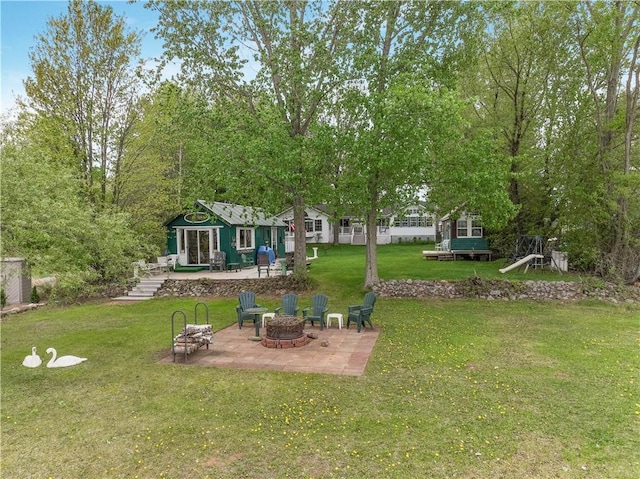 630 W Lake Dr, Shell Lake, WI 54871 - view of grassy yard with a fire pit, a patio, and an outbuilding