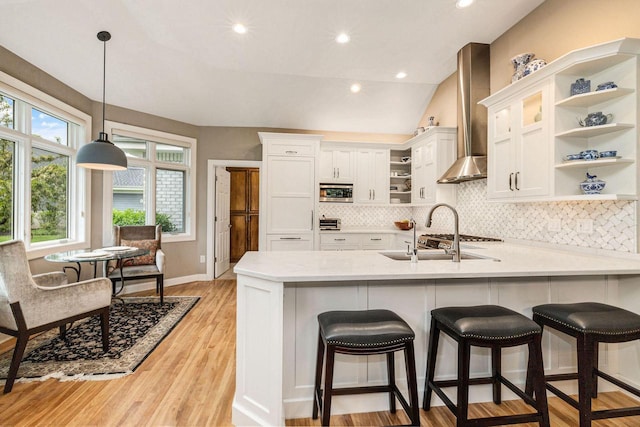 845 Lake Rd Unit D, Brookfield, WI 53005 - kitchen with open shelves, a peninsula, wall chimney exhaust hood, white cabinets, and vaulted ceiling