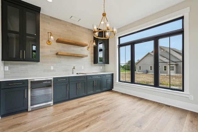 N67W27095 Fanad Dr, Lisbon, WI 53089 - kitchen with beverage cooler, a chandelier, decorative backsplash, light countertops, and baseboards