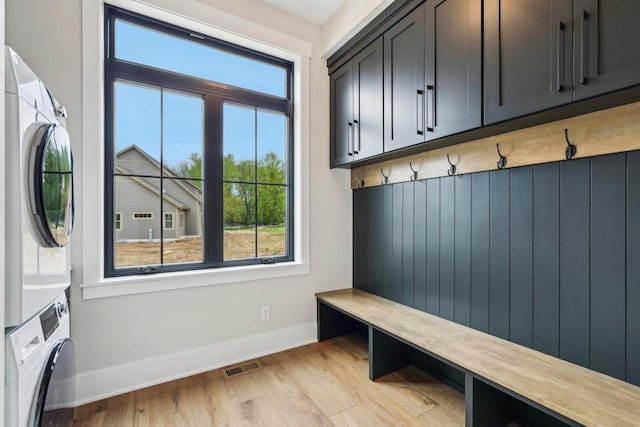 N67W27095 Fanad Dr, Lisbon, WI 53089 - mudroom featuring stacked washer and clothes dryer, plenty of natural light, baseboards, and light wood finished floors