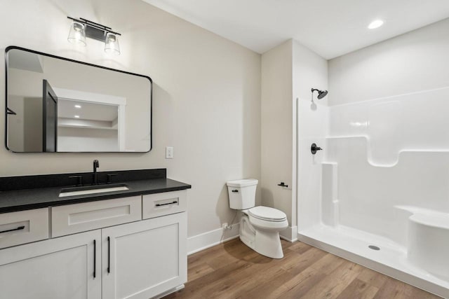 N67W27095 Fanad Dr, Lisbon, WI 53089 - bathroom featuring vanity, baseboards, wood finished floors, toilet, and a shower