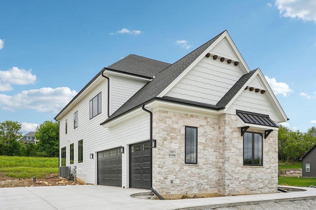 N67W27095 Fanad Dr, Lisbon, WI 53089 - view of side of home with stone siding, a shingled roof, driveway, and cooling unit