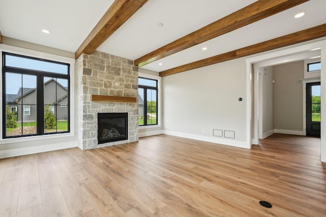 N67W27095 Fanad Dr, Lisbon, WI 53089 - unfurnished living room with a stone fireplace, light wood-style flooring, beam ceiling, baseboards, and recessed lighting