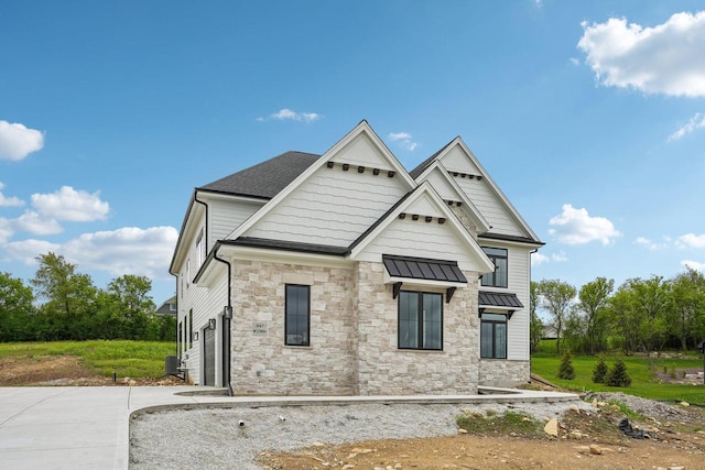 N67W27095 Fanad Dr, Lisbon, WI 53089 - rear view of property with stone siding, a standing seam roof, and roof with shingles