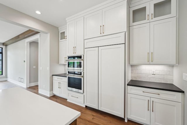 N67W27095 Fanad Dr, Lisbon, WI 53089 - kitchen featuring wood finished floors, tasteful backsplash, stainless steel double oven, recessed lighting, and glass insert cabinets