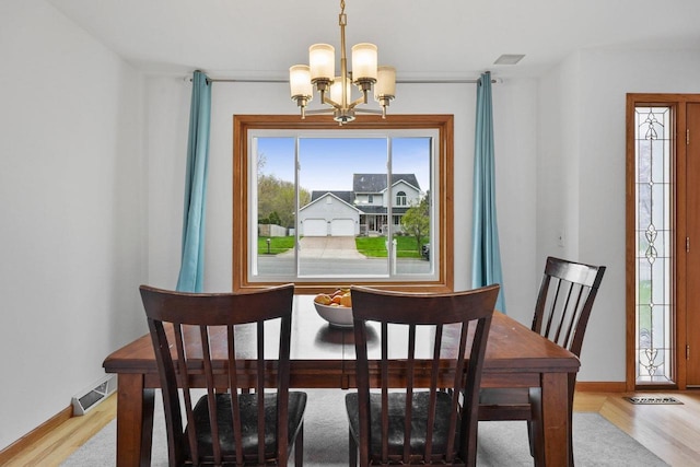 517 Brule Pkwy, Deforest, WI 53532 - dining space featuring a chandelier, light wood-style flooring, and baseboards