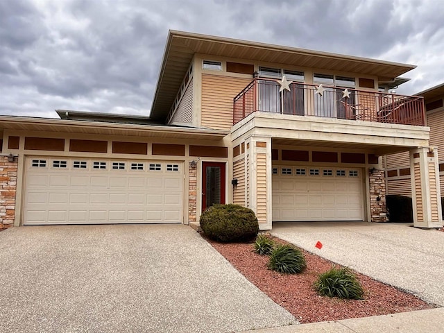 1021 W Pleasant St Unit 5, Portage, WI 53901 - view of front of home featuring driveway, stone siding, and a balcony