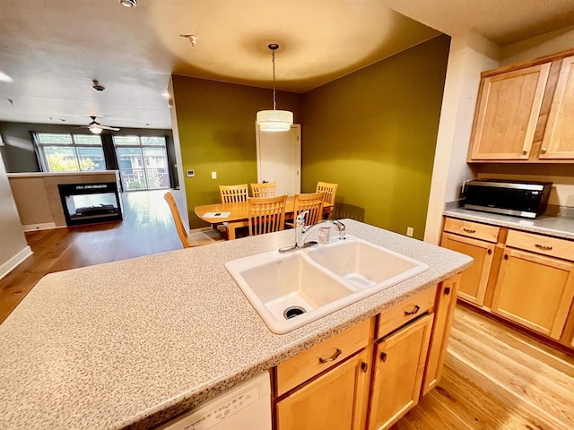 1021 W Pleasant St Unit 5, Portage, WI 53901 - kitchen featuring stainless steel microwave, a sink, light wood finished floors, light countertops, and a multi sided fireplace