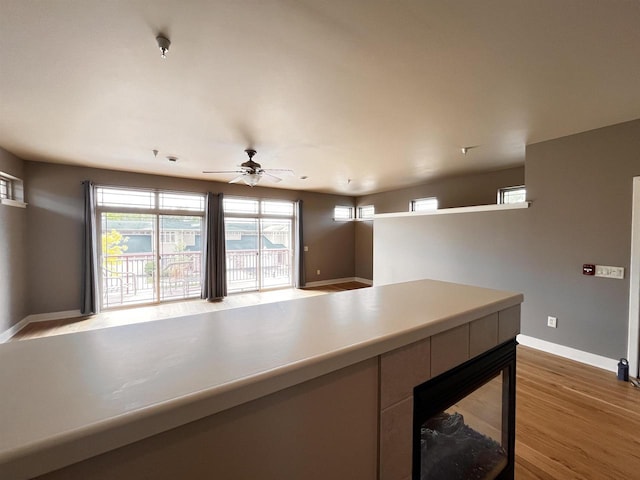 1021 W Pleasant St Unit 5, Portage, WI 53901 - kitchen with wood finished floors, baseboards, ceiling fan, and light countertops