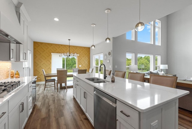 6340 Congress Dr, West Bend, WI 53095 - kitchen with appliances with stainless steel finishes, a sink, premium range hood, a chandelier, and plenty of natural light