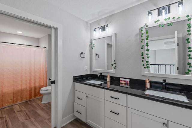 6340 Congress Dr, West Bend, WI 53095 - full bath with wood finished floors, double vanity, toilet, and a shower with shower curtain