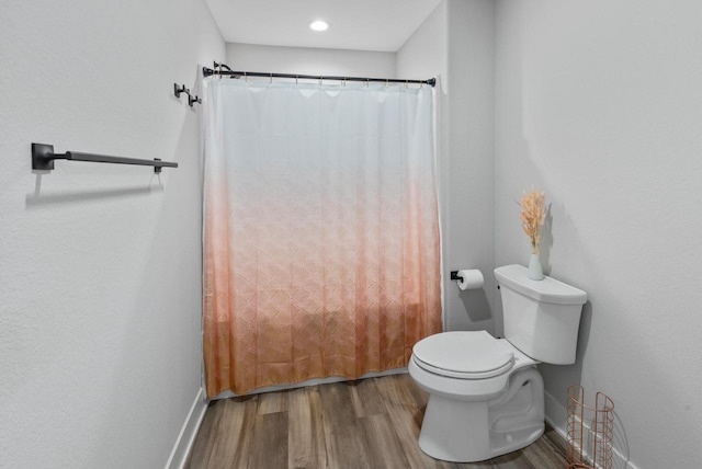 6340 Congress Dr, West Bend, WI 53095 - full bath with wood finished floors, toilet, baseboards, and a shower with shower curtain